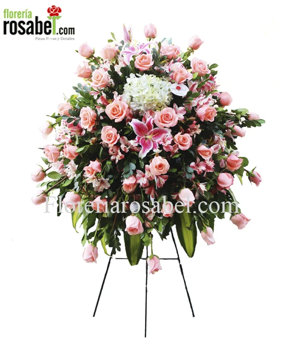 Arreglo de lágrima fúnebre de rosas rosadas sobre parante de madera trípode.