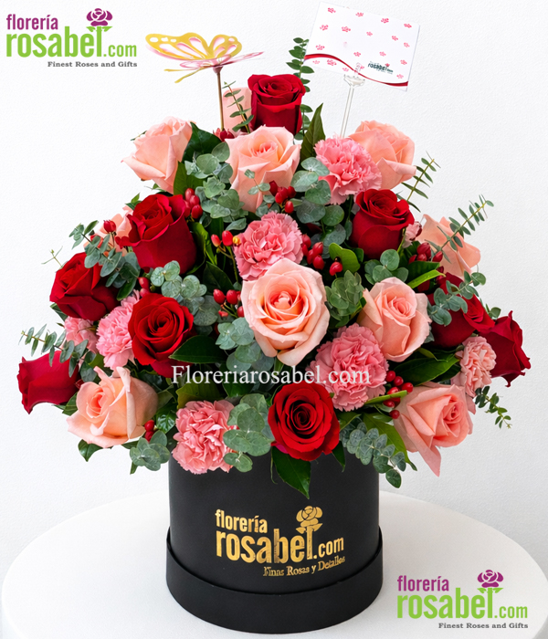 Sombrerera con rosas rojas y rosadas, claveles y follajes naturales